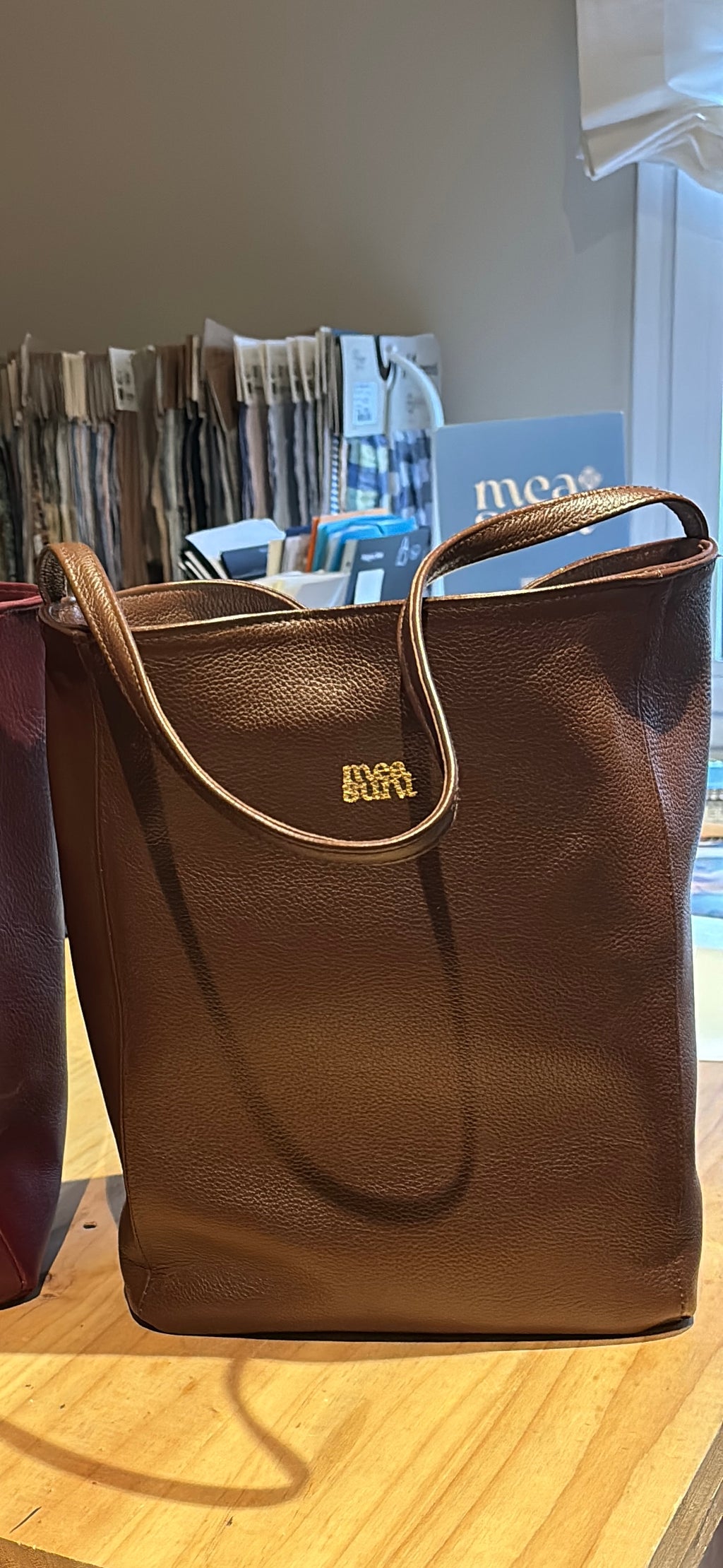 Bolso Atenea marrón vista frontal con asas largas y logotipo dorado – MEASUNT