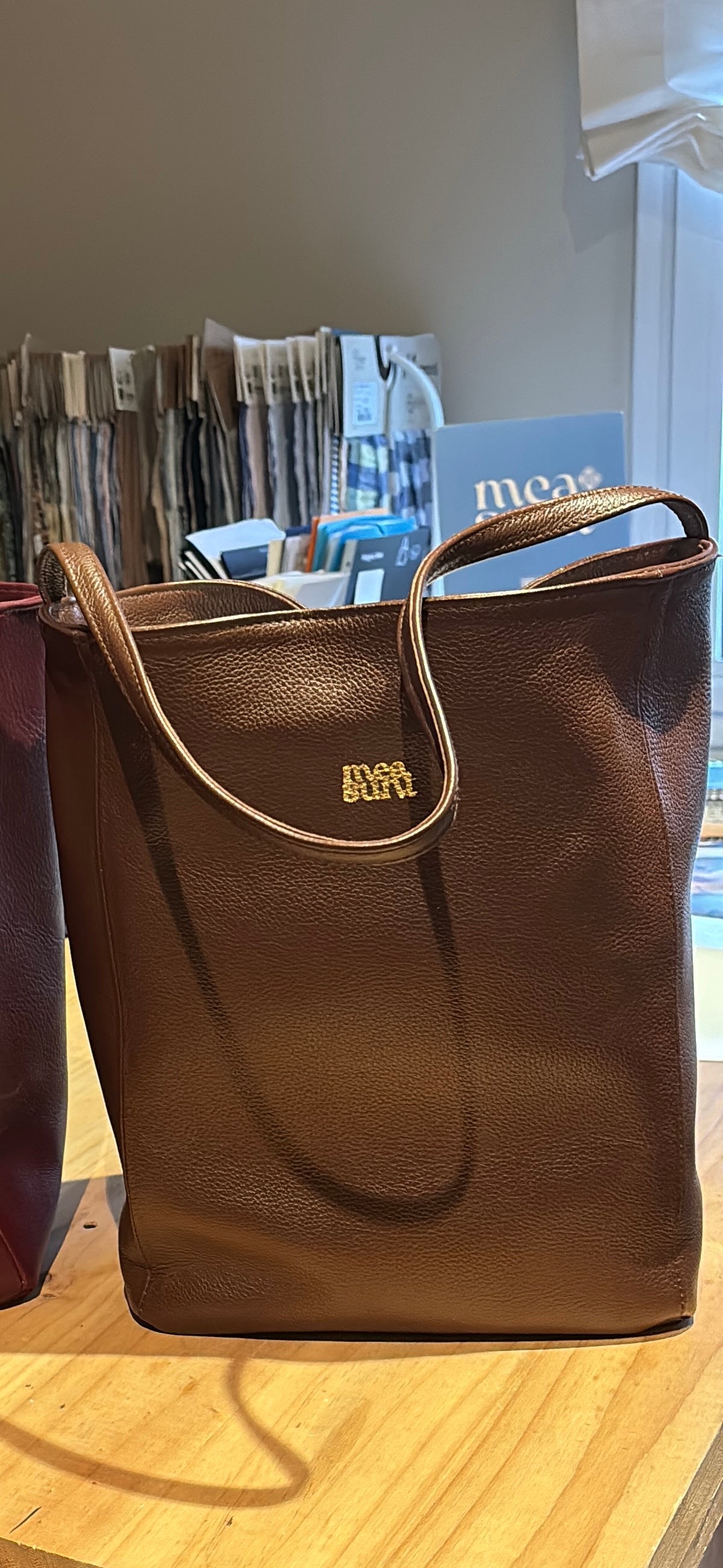 Bolso Atenea marrón vista frontal con asas largas y logotipo dorado – MEASUNT